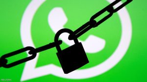 A photo illustration shows a chain and a padlock in front of a displayed Whatsapp logo